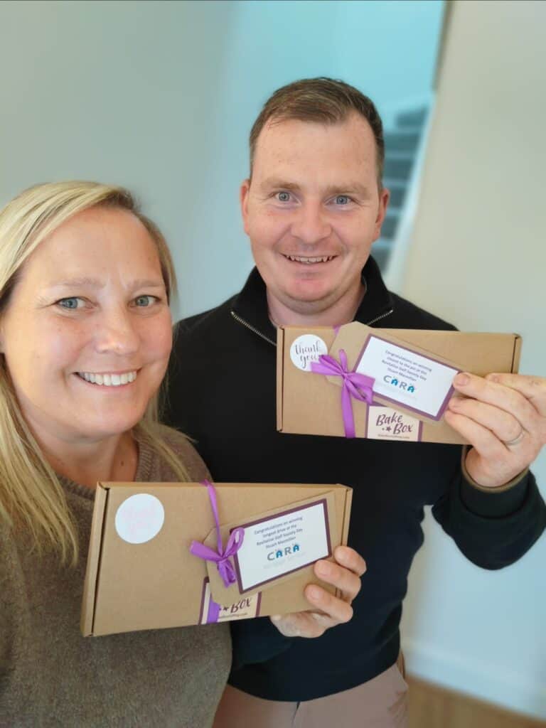 Jennifer with Stuart from CARA Mortgage Services showing off BakeBox Gifts which were given at prizes at the Revitalise Networking golf day