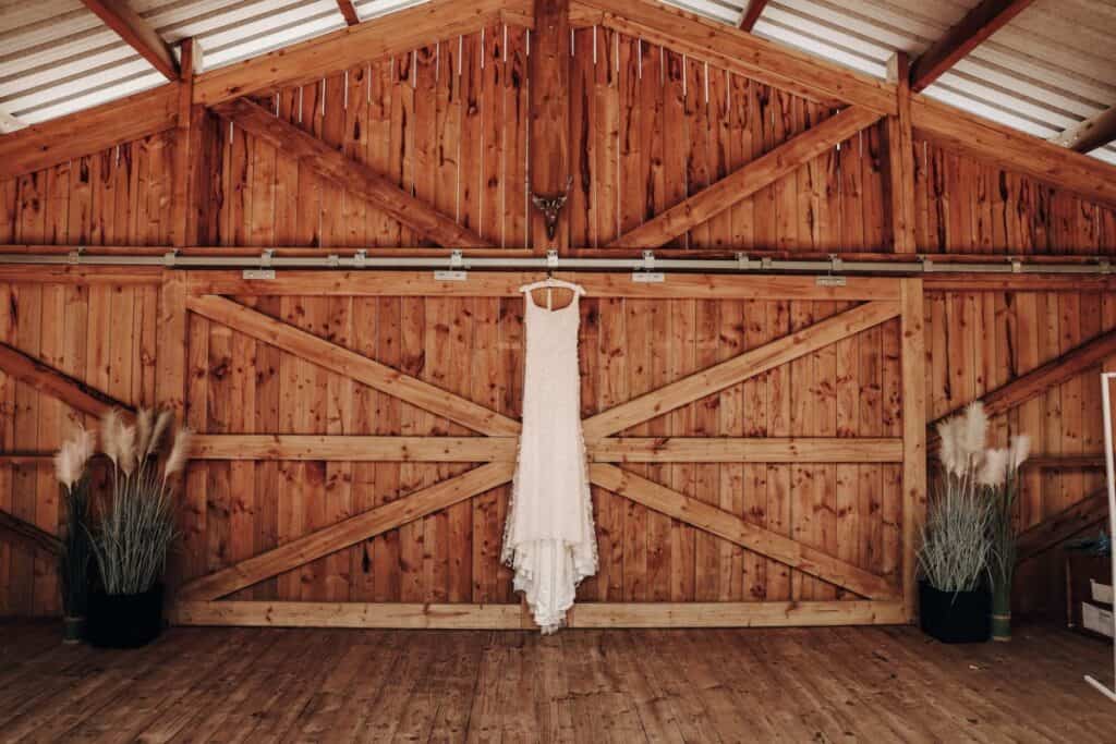 Wedding dress hanging on barn door at Eden Leisure Village