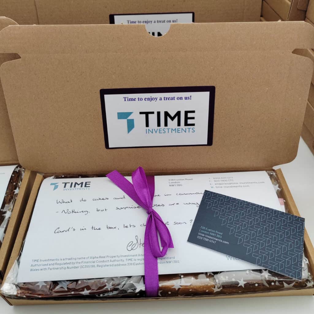 Corporate BakeBox Gift with Time Investments logo and a message saying "Time to enjoy a treat on us!" Also include is a compliments slip and business card.