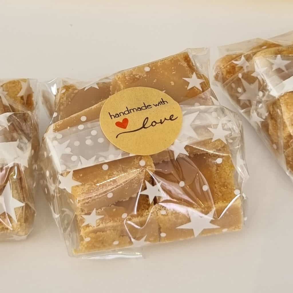 6 squares of Scottish Tablet wrapped in compostable cellophane with a sticker saying "Handmade With Love"